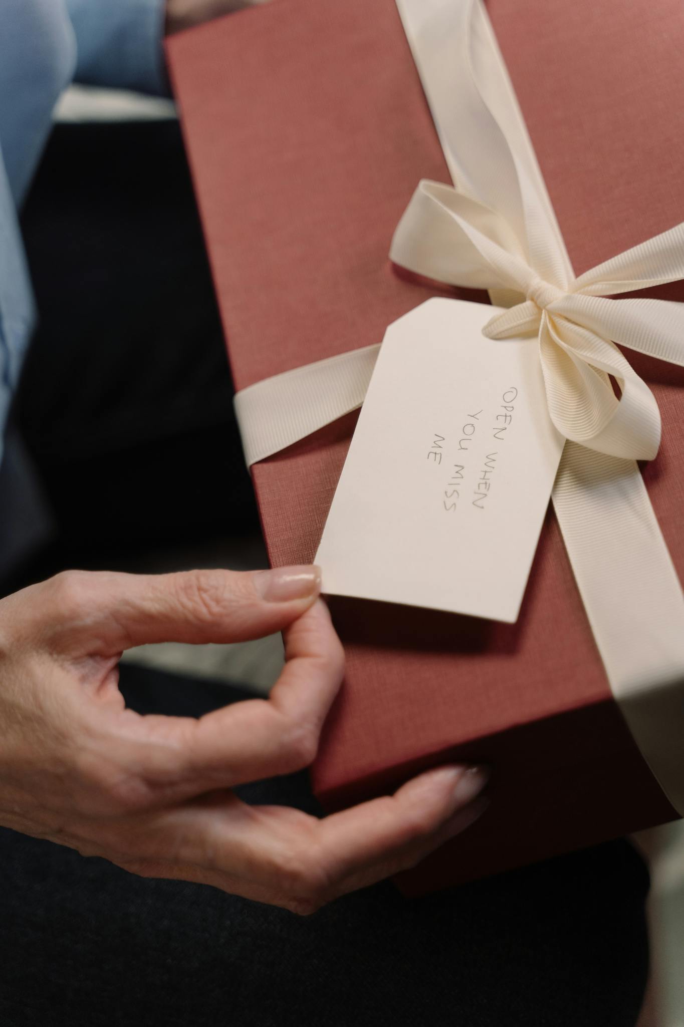Close-up of a stylishly wrapped gift box with an attached personal note.